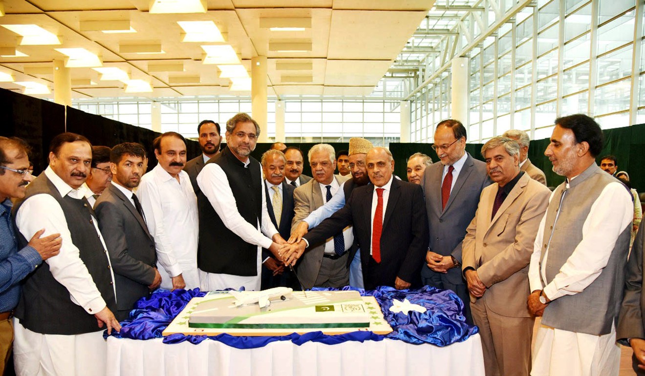 Pakistani Prime Minister Shahid Khaqan Abbasi cuts a cake after inaugurating Islamabad International Airport in Islamabad. Photo: Xinhua