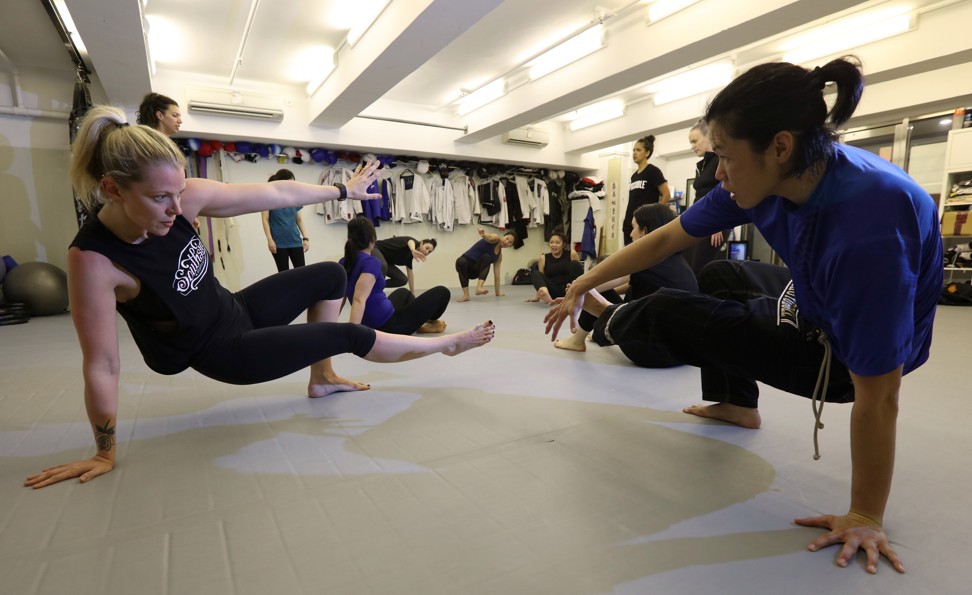 An instructor demonstrates a self-defence move alongside one of her students. Photo: Felix Wong
