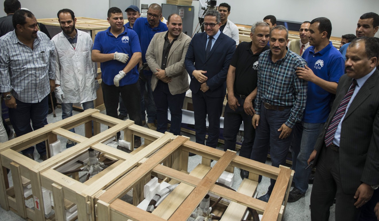 The Egyptian Minister of Antiquities Khaled el-Enany (centre) stands in front of boxes contaning pieces of the last chariot of Tutankhamen at the Grand Egyptian Museum (GEM), Giza, Egypt, on Saturday. Photo: EPA-EFE