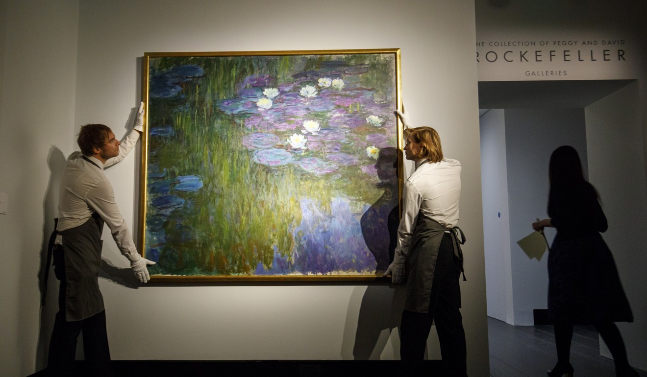 Gallery assistants pose with the painting “Nympheas en fleur” by French artist Claude Monet during a photocall in London on February 20. Photo: EPA