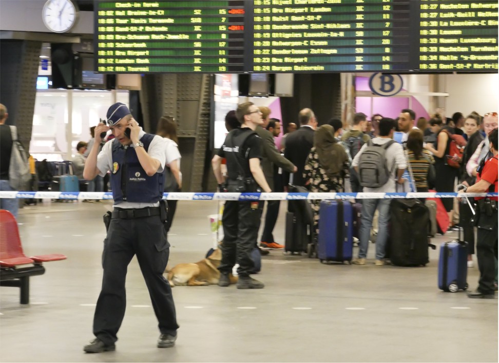 A police officer speaks on a mobile phone next to a safety perimeter at a Brussels train station after reports of an incident Wednesday. Police said that a suspect fired a gun in a crowd, causing panic, but that nobody was killed or injured. Photo: AP