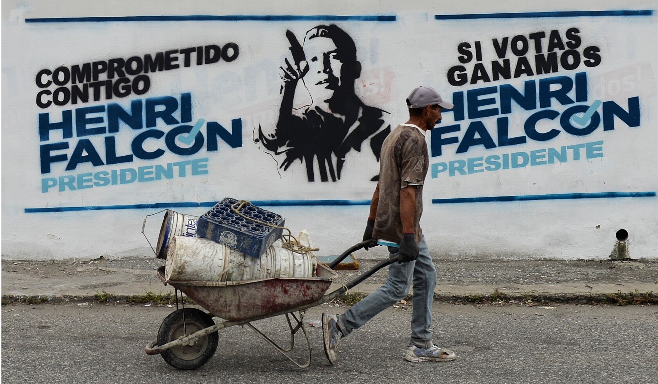 A worker passes electoral propaganda for Venezuelan opposition presidential candidate Henri Falcon, in Barquisimeto, Venezuela. Photo: AFP