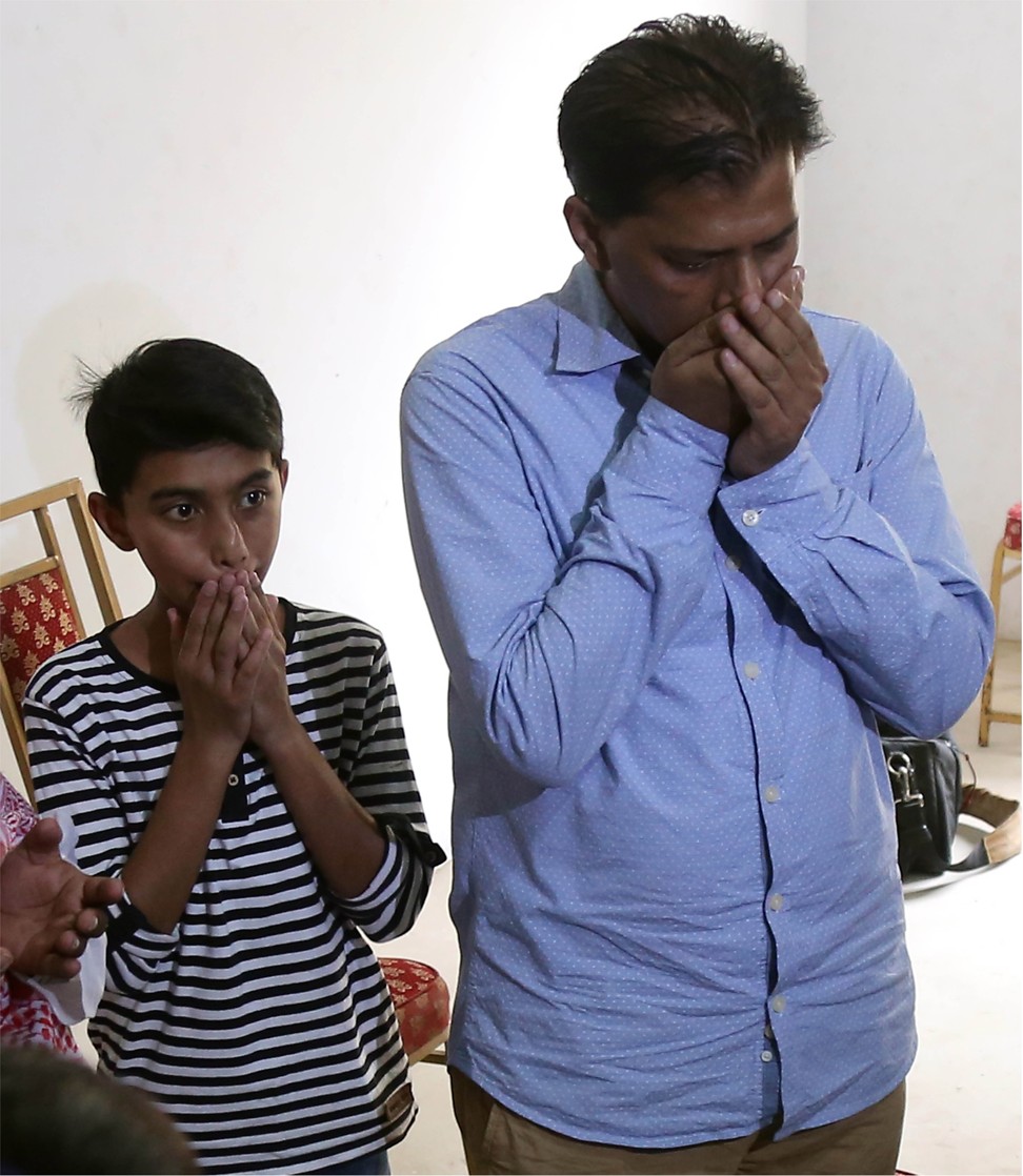 Abdul Aziz Sheikh and his his son Ali react on Saturday after his daughter was killed. Photo: EPA-EFE