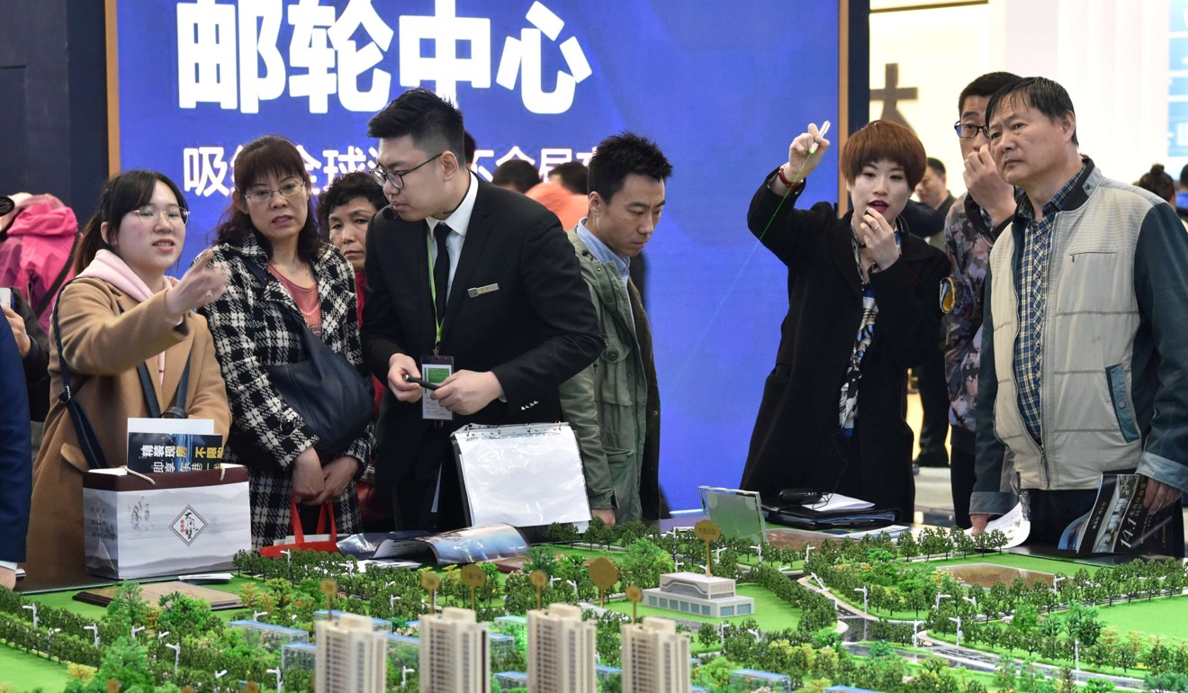 Sales staff show models of a residential compound to visitors during the Spring Real Estate Fair in Dalian, China, on April 12. Real estate accounts for a substantial part of Chinese households’ investment portfiolios, but this is gradually changing. Photo: Reuters