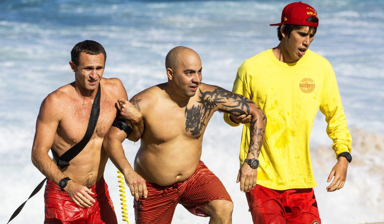 Lifeguards rescue a bather from waves at Waimea Bay Beach Park on Oahu island, in Hawaii.