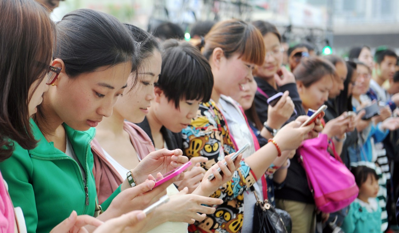A group of young Chinese women use their smartphones at a shopping centre in Taiyuan city, in north China's Shanxi province. Photo: