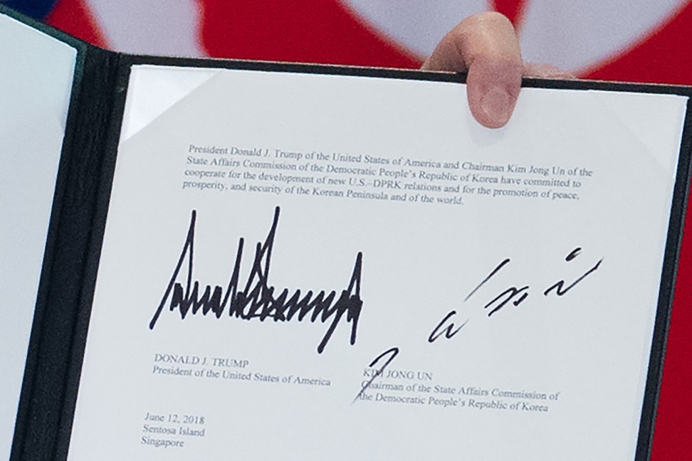 The signatures of US President Donald Trump and North Korean leader Kim Jong-un are seen on a document held up by Trump following a signing ceremony during their historic US-North Korea summit on Tuesday. Photo: AFP