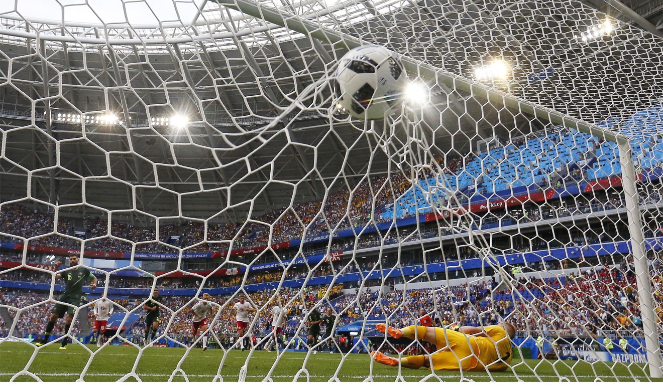 Mile Jedinak (left) of Australia dispatches his penalty kick to level the score with Denmark in the World Cup. Photo: EPA