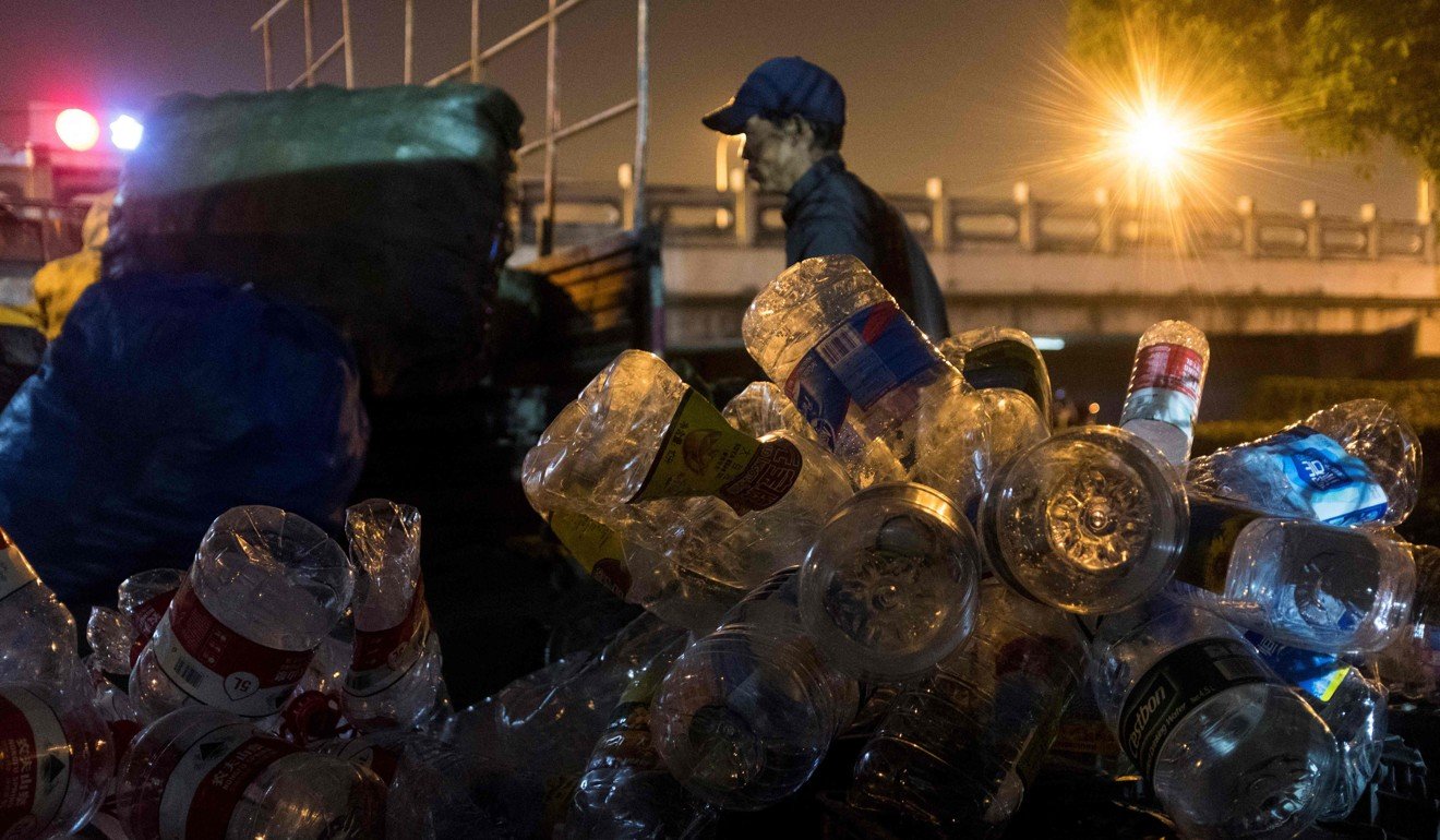 This picture taken on May 11 shows a scrap collector sorting plastic waste at a rubbish dump in Shanghai. Photo: AFP