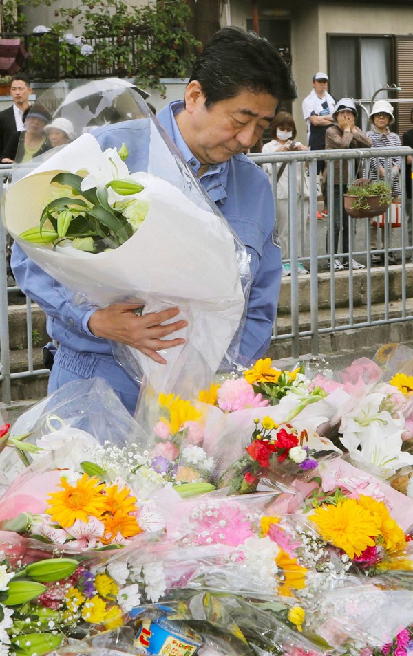Japanese Prime Minister Shinzo Abe places flowers at a memorial set up at Juei Elementary School in Takatsuki, Osaka, where a nine-year-old pupil was crushed to death under a concrete wall. Photo: Kyodo