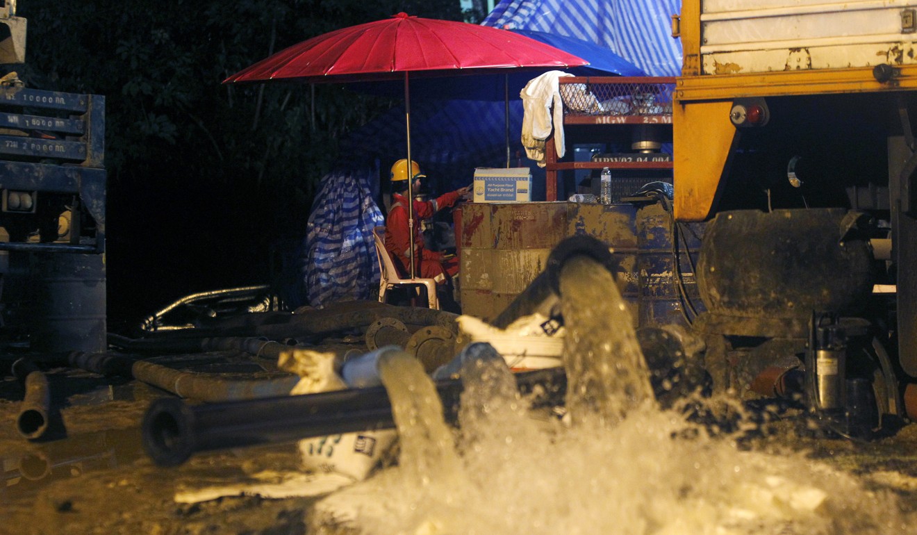 Thai workers pump water out of the cave complex. Photo: EPA
