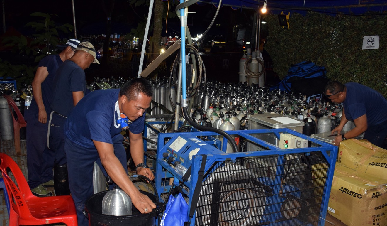 Rescuers prepare oxygen tanks for the rescue operation of a group of 12 young soccer players and their coach. Photo: EPA