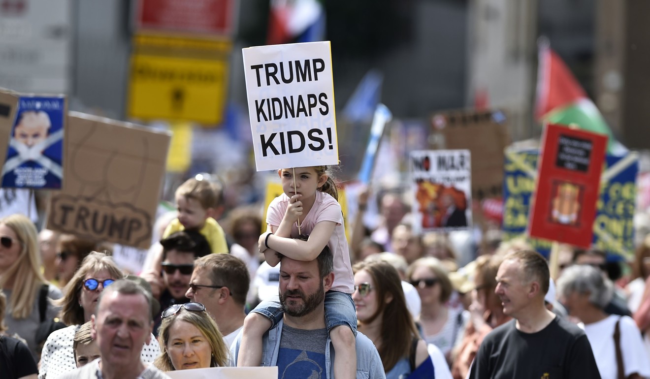 Protesters carry placards as they take part in the Scotland United Against Trump demonstration through the streets of Edinburgh on Saturday. Photo: AFP