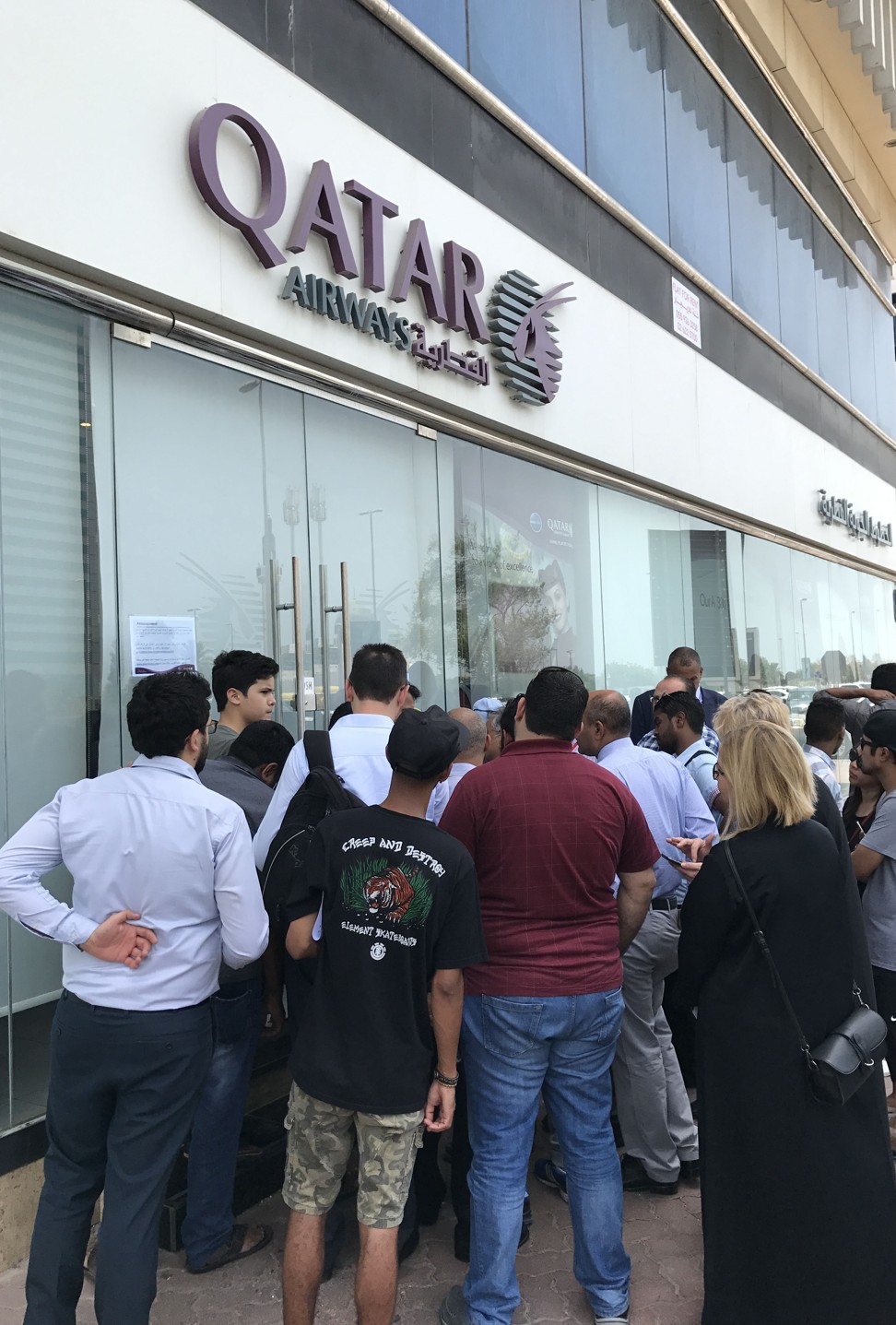 People gather outside a branch of Qatar Airways in the United Arab Emirate of Abu Dhabi on June 6, 2017, a day before the UAE cut diplomatic ties with Qatar and gave Qataristwo weeks to leave the country. Photo: Agence France-Presse