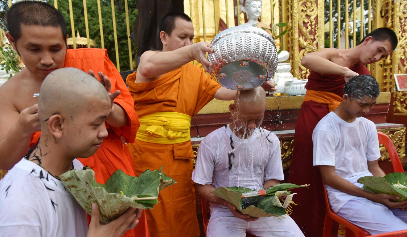 Buddhist monks shave the heads of the rescued Thai boys. Photo: AFP