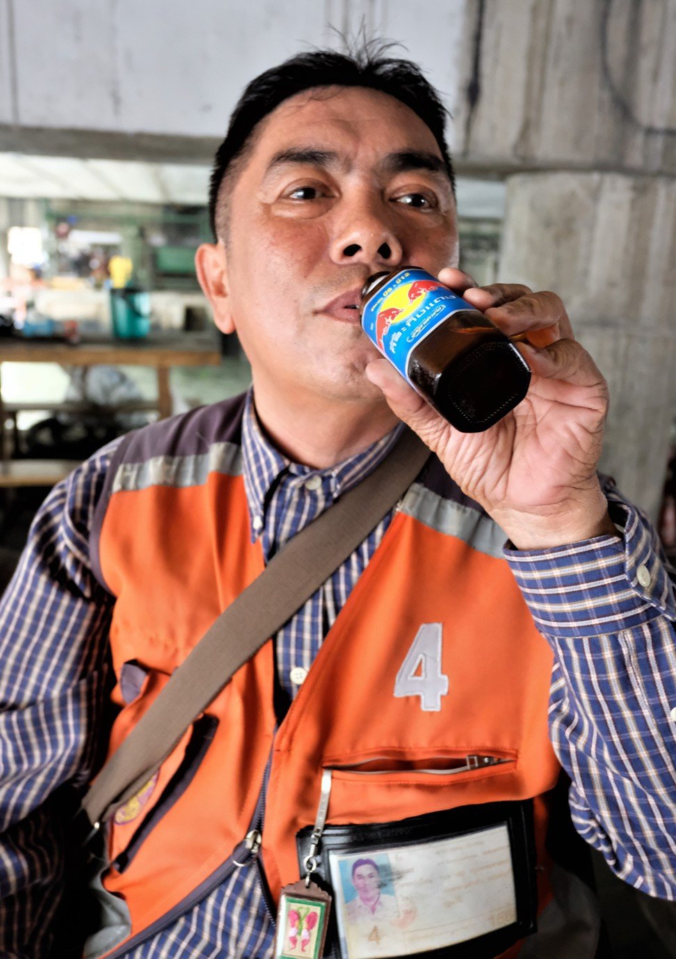Phakhaphon Kheamthong, a motorcycle taxi driver in Bangkok, drinks a bottle of Krating Daeng during one of his 12-hour shifts. Photo: Tibor Krausz