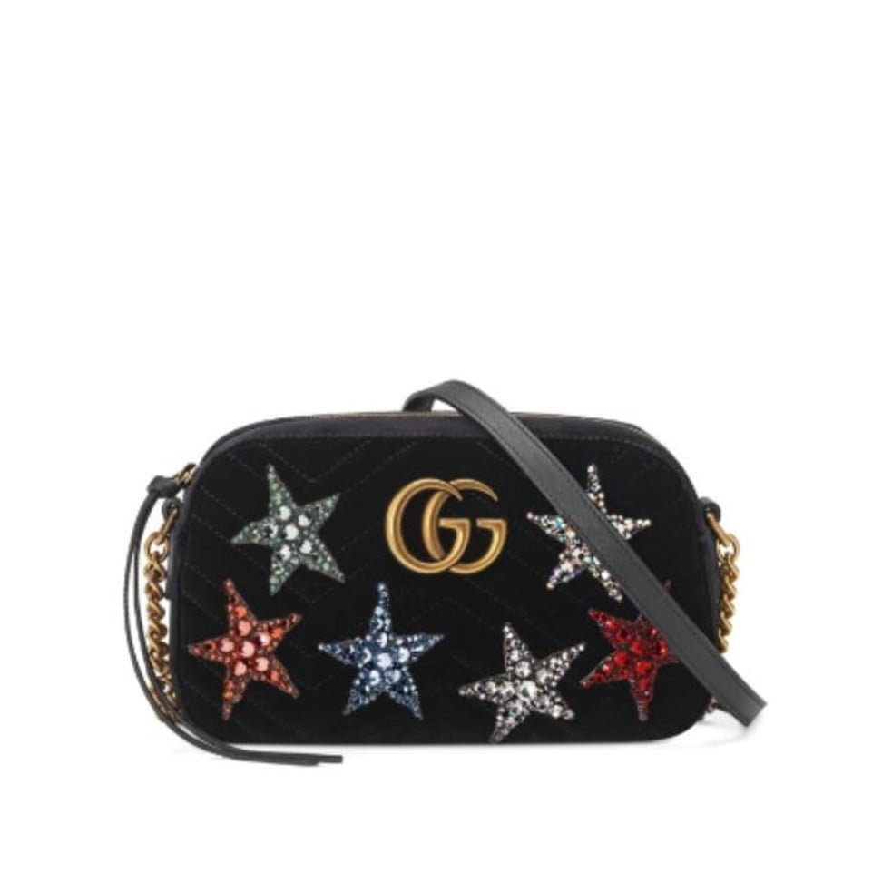 The Gucci GG Marmont shoulder bag comes embellished with star appliqués embroidered with glimmering crystals in various colours.