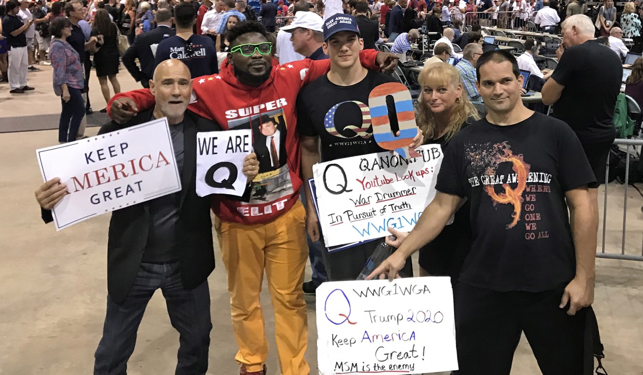 Donald Trump supporters who are proponents of the “QAnon” conspiracy theory pose for a photo after Trump spoke at a rally in Tampa, Florida, on Tuesday. Photo: TNS