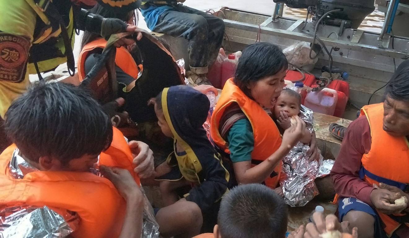 A Thai volunteer group rescues flood survivors, including a baby trapped in a remote village, close to the swollen river in Attapeu province, Laos. Photo: AFP