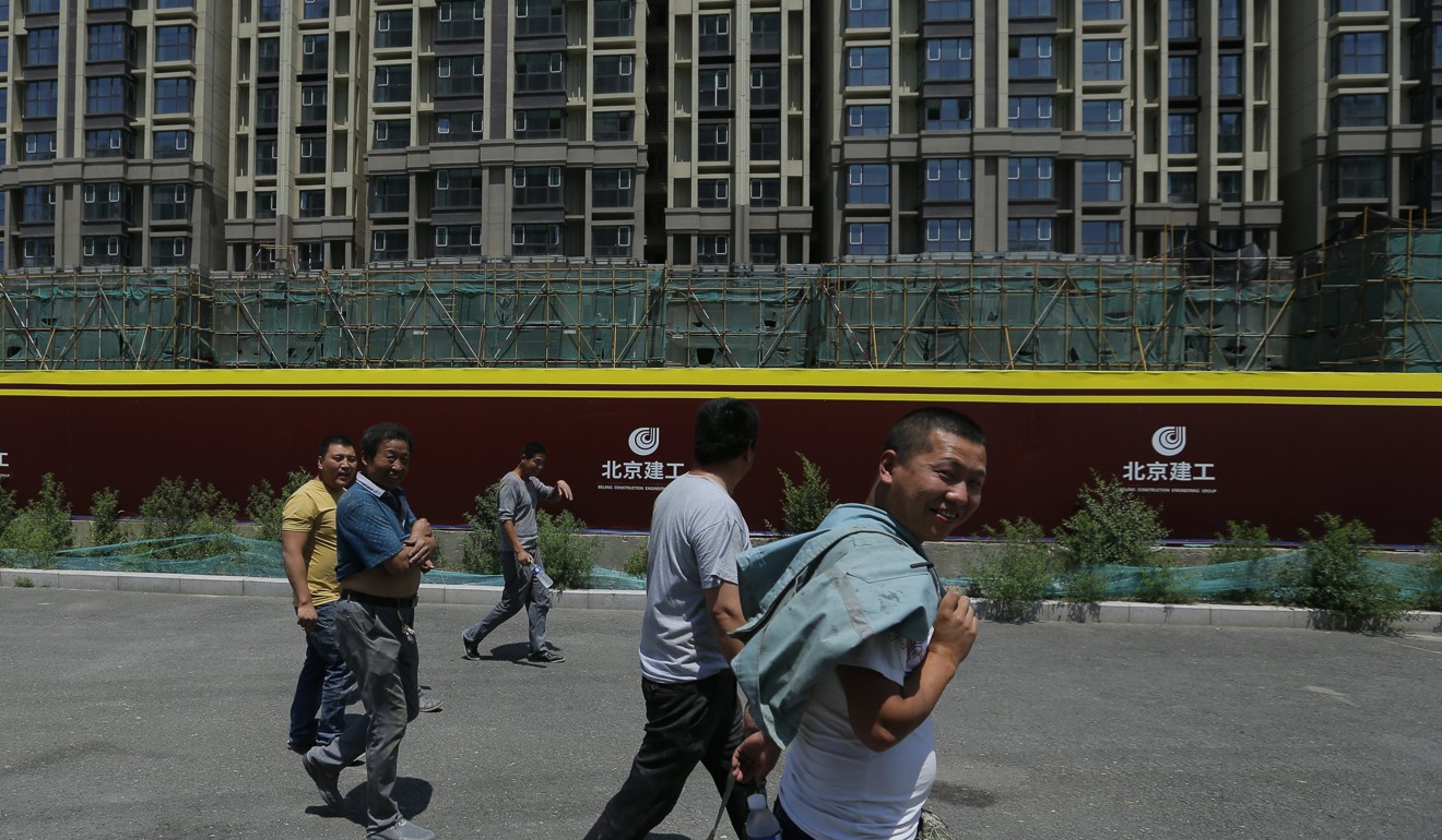 Migrant workers walk at a construction site in Beijing. The Chinese government has implemented a string of measures to control home price hikes over the past two years. Photo: EPA
