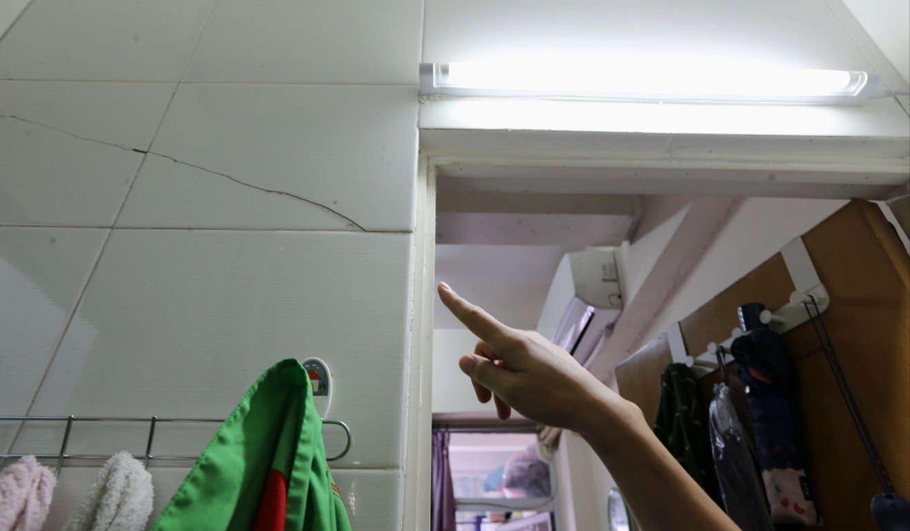 Lily Yeung, who lives in a building on Ma Tau Wai Road in To Kwa Wan, points to a crack that has opened up in the wall of her flat. Photo: Dickson Lee