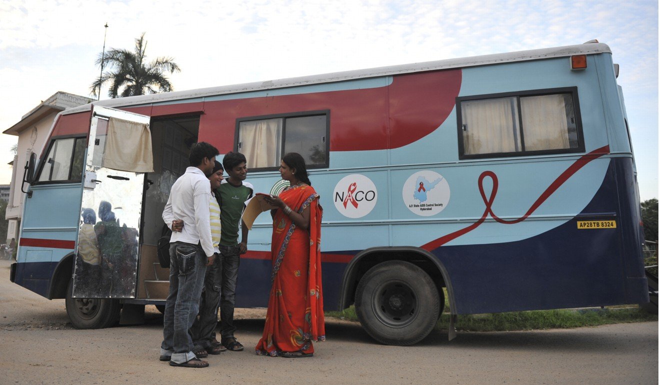 An Indian transgender educator (right) talks to youngsters in front of a mobile counselling and testing centre in Hyderabad, India. Photo: AFP