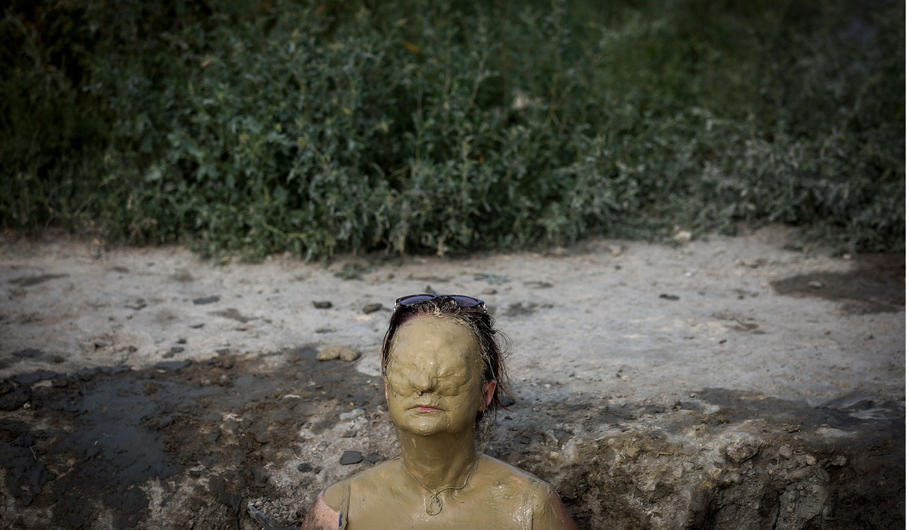 A woman covered with mud sunbathes in Ovca, near Belgrade, on August 11. Photo: Agence France-Presse