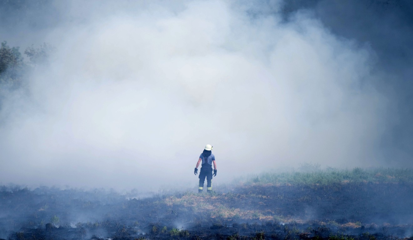 A firefighter stands on a burning field on August 8 in Vechelde, northwestern Germany. Photo: Agence France-Presse
