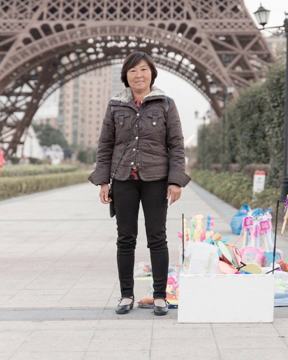 A woman sells souvenirs in front of the Eiffel Tower in Tianducheng, China. Photo: Francois Prost