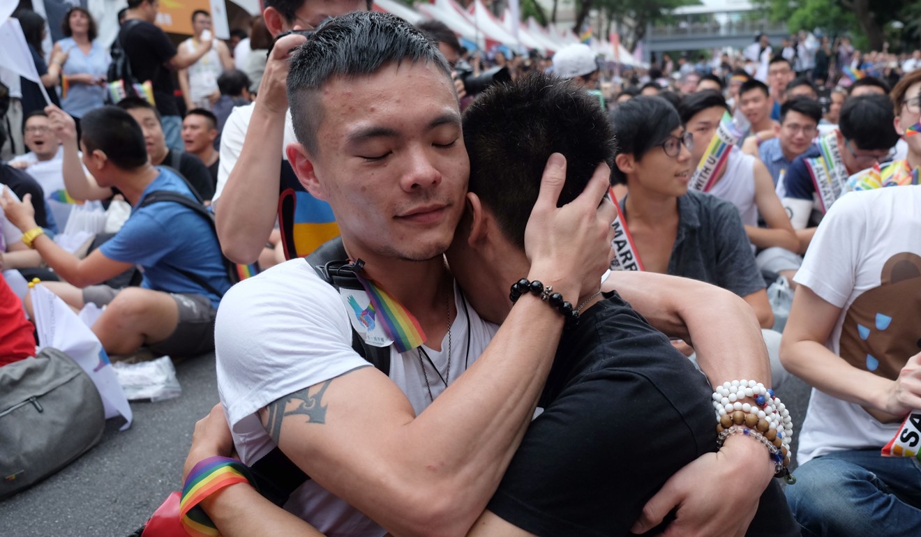 Same-sex activists hug outside the parliament in Taipei on May 24, 2017 as they celebrate the landmark decision paving the way for the island to become the first place in Asia to legalise gay marriage. Picture: AFP
