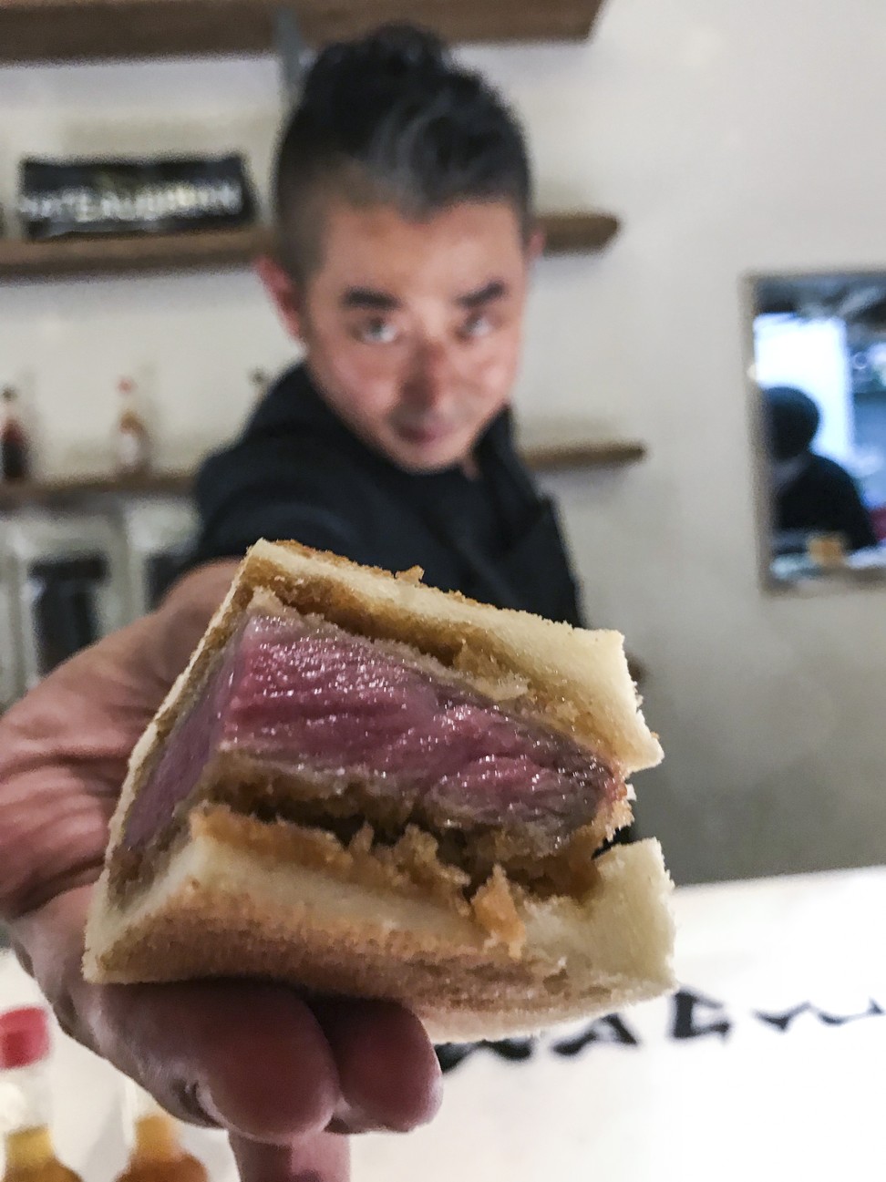 Chef Hisato Hamada hands out quarters of his wagyu beef cutlet sandwiches at Elephant Grounds in Fashion Walk, Hong Kong. His Tokyo restaurant Wagyumafia will open a branch in the city next month. Photo: Bernice Chan