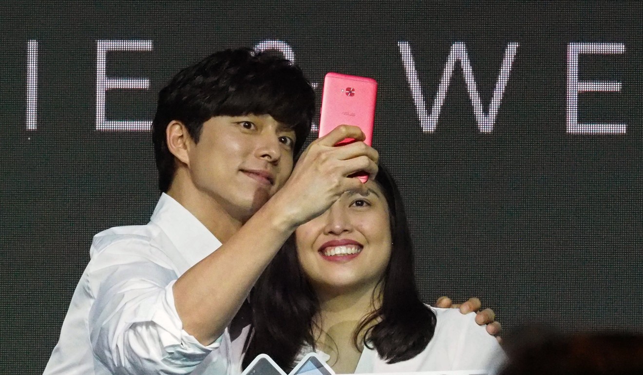 South Korean actor Gong Yoo (left) takes a selfie with a fan at the launch of a smartphone, in Taipei on August 17, 2017. As people share more of their lives online, the need to protect digital human rights becomes more pressing. Photo: EPA