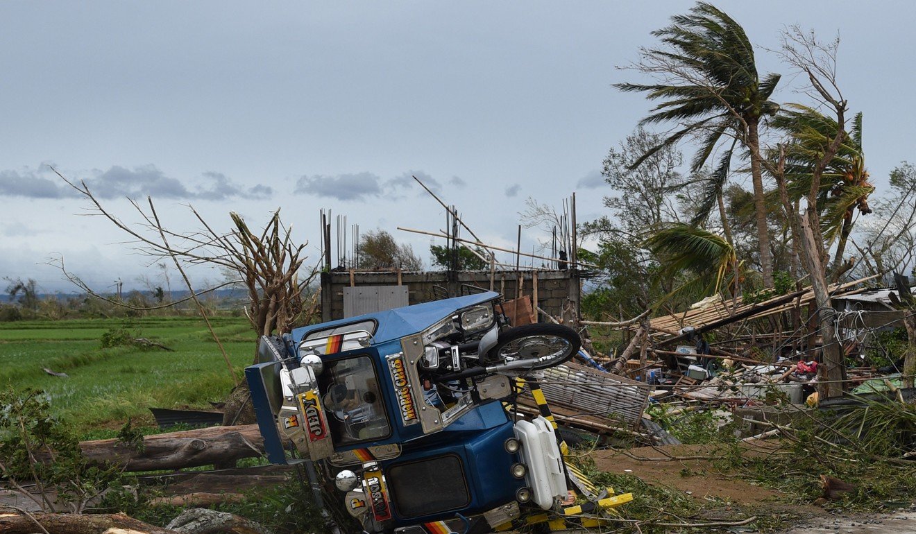 An overturned tricycle next to a destroyed house in Alcala, Cagayan province. Photo: AFP