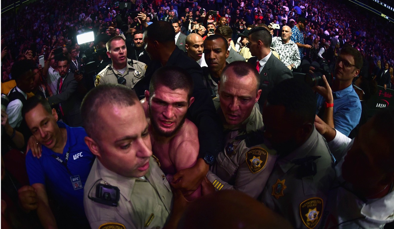 Khabib Nurmagomedov is escorted out of the arena by police. Photo: AFP