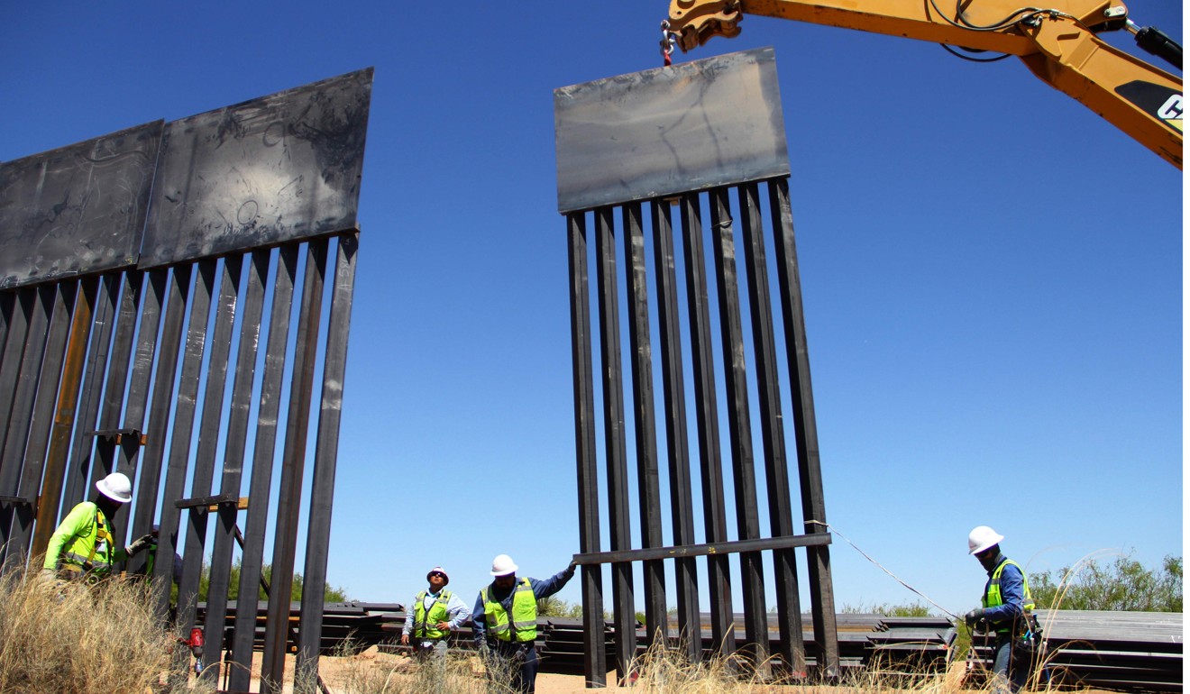 File photo of workers replacing an old section of the barrier between the US and Mexico. Photo: AFP
