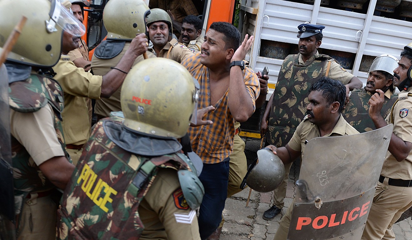 Indian police take a man into custody as they stop a bus of protesters rallying against a Supreme Court verdict revoking a ban on women’s entry to a Hindu temple on Wednesday. Photo: AFP
