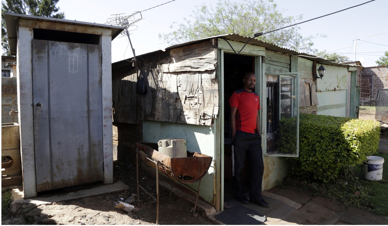 Somsy Matso standing at the door of his shacks in Winnie Mandela Informal Settlement in Tembisa, of east of Johannesburg, South Africa on October 16, 2018. Photo: AP