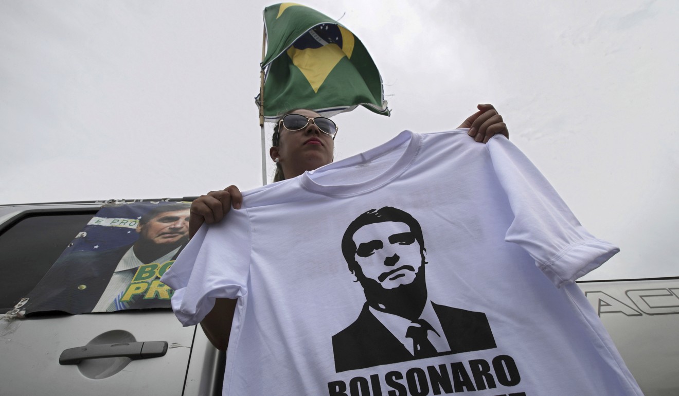 A supporter sells T-shirts with an image of right-wing presidential candidate Jair Bolsonaro, at a bus station in Brasília, Brazil. Photo: AP