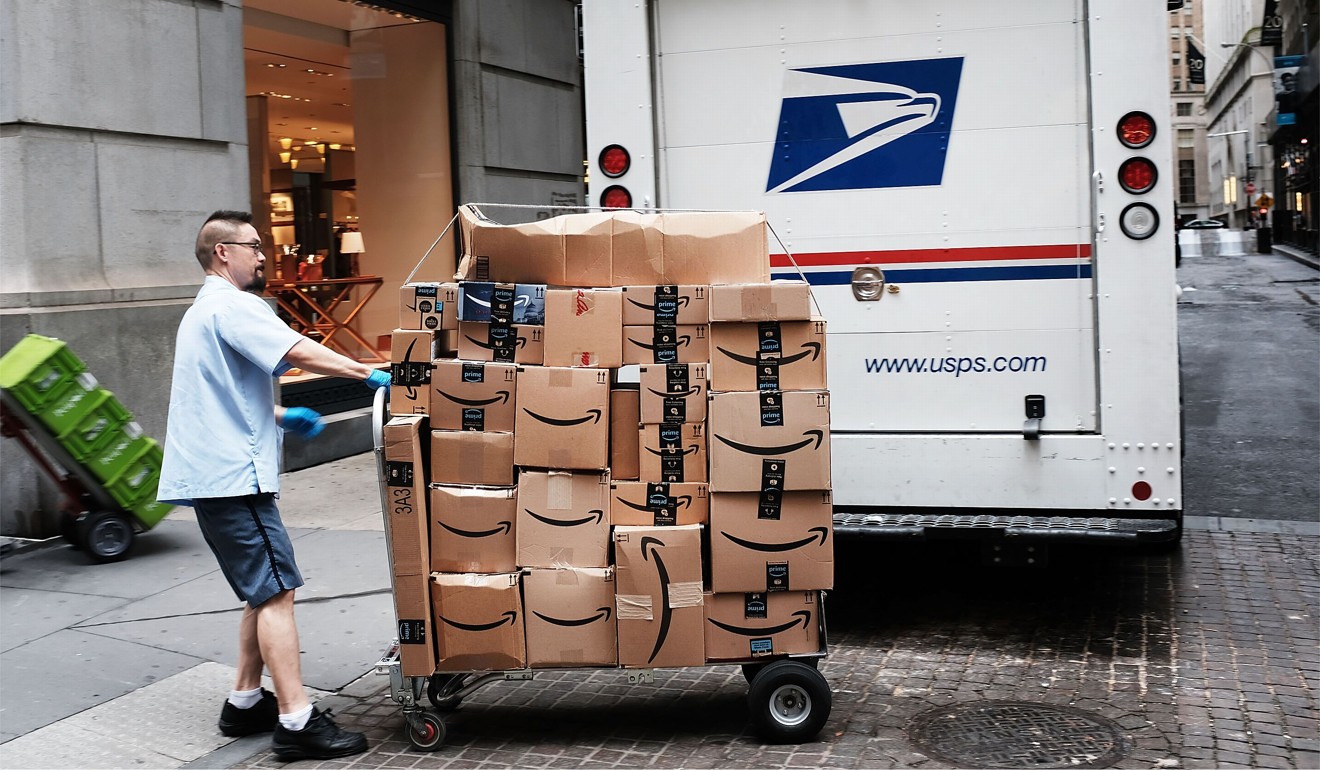 A US Postal Service worker delivers Amazon boxes in New York last week. Photo: Getty Images via AFP
