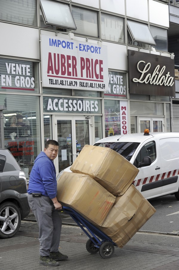 A man carries goods on a trolley in the business centre in Aubervilliers, north of Paris, where there are hundreds of textile wholesale shops owned by Chinese traders. Photo: AFP