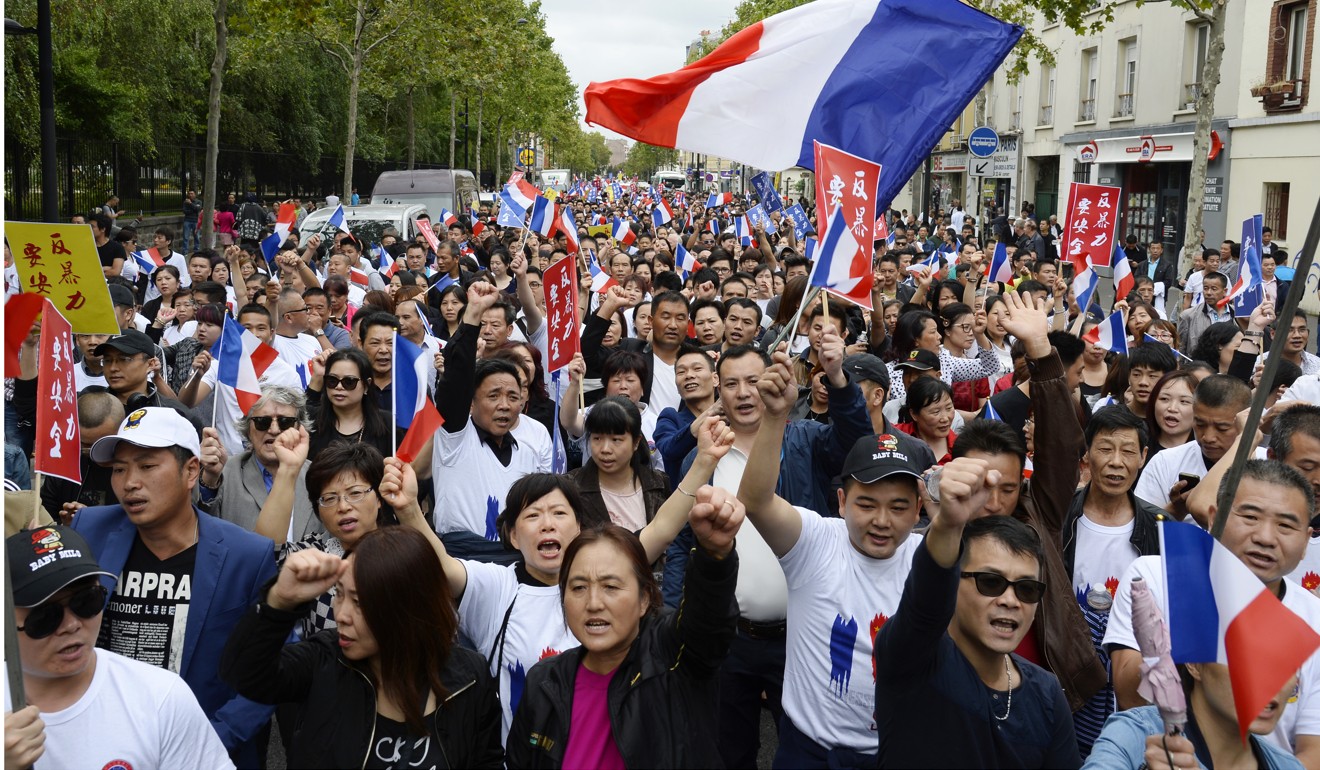 People wave French flags during a demonstration in Paris on August 21, 2016, organised by several Chinese community groups to demand better protection after the death of Zhang Chaolin. Photo: AFP
