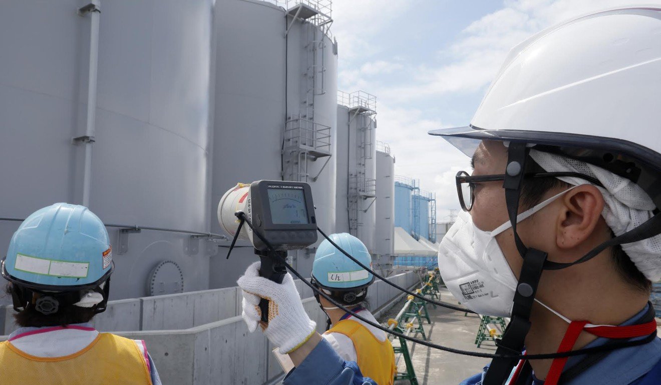 Staff of the Tokyo Electric Power Company measure radiation levels around the storage tanks of radiation-contaminated water at the tsunami-crippled Tokyo Electric Power Company Fukushima Daiichi nuclear power plant, in Okuma, in July. The Japanese government has been pushing for former residents to return to the area seven years after the nuclear disaster, but this has been met with scepticism. Photo: AFP