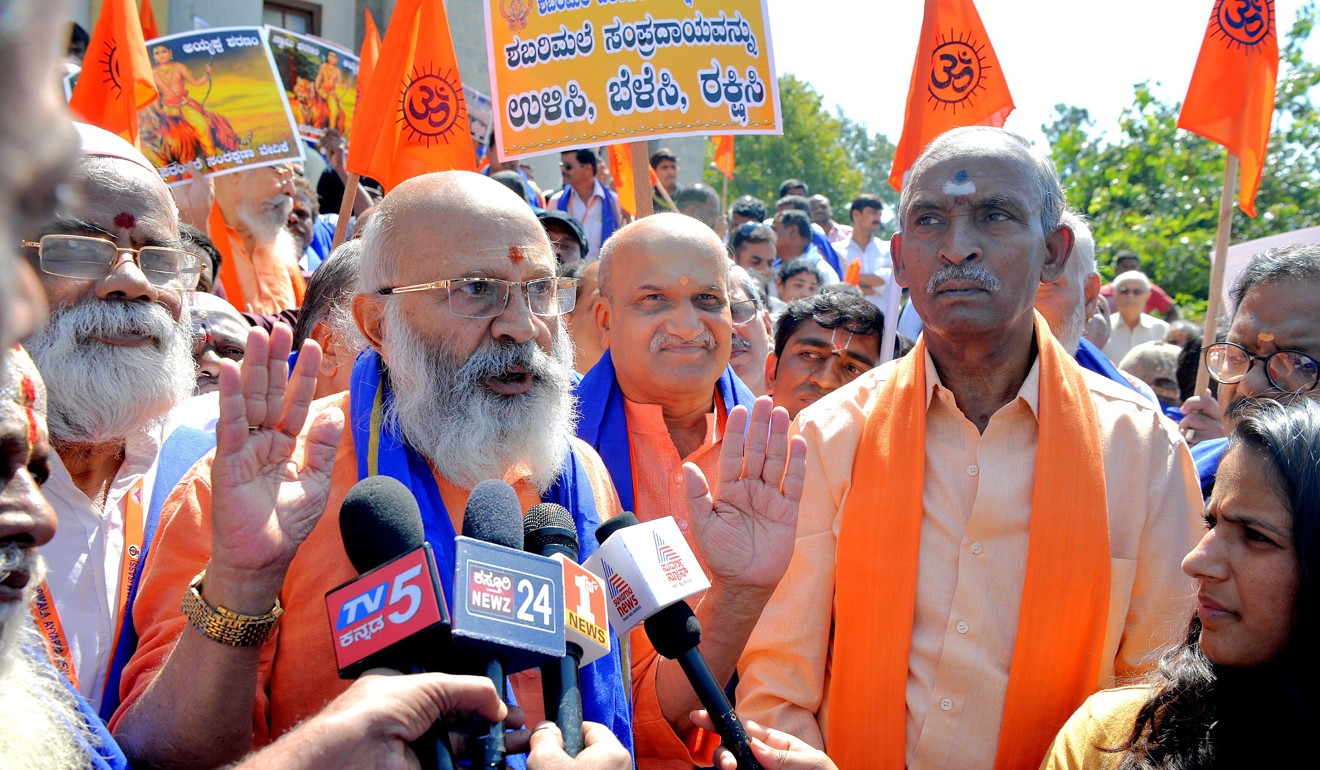 S. Shivram, a devotee of Hindu deity Ayyappa, gestures while addressing the media as Rashtriya Hindu Sena founder and activist Pramod Muthalik (centre) looks on before a rally in Bangalore on October 27, 2018, urging a reversal of a Supreme Court decision to allow women of ‘menstruating age’ into Sabarimala Temple in Kerala. Photo: AFP
