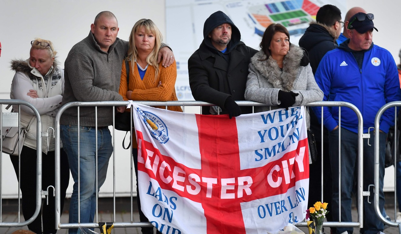 Supporters pause at the pile of floral tributes outside King Power Stadium. Photo: AFP