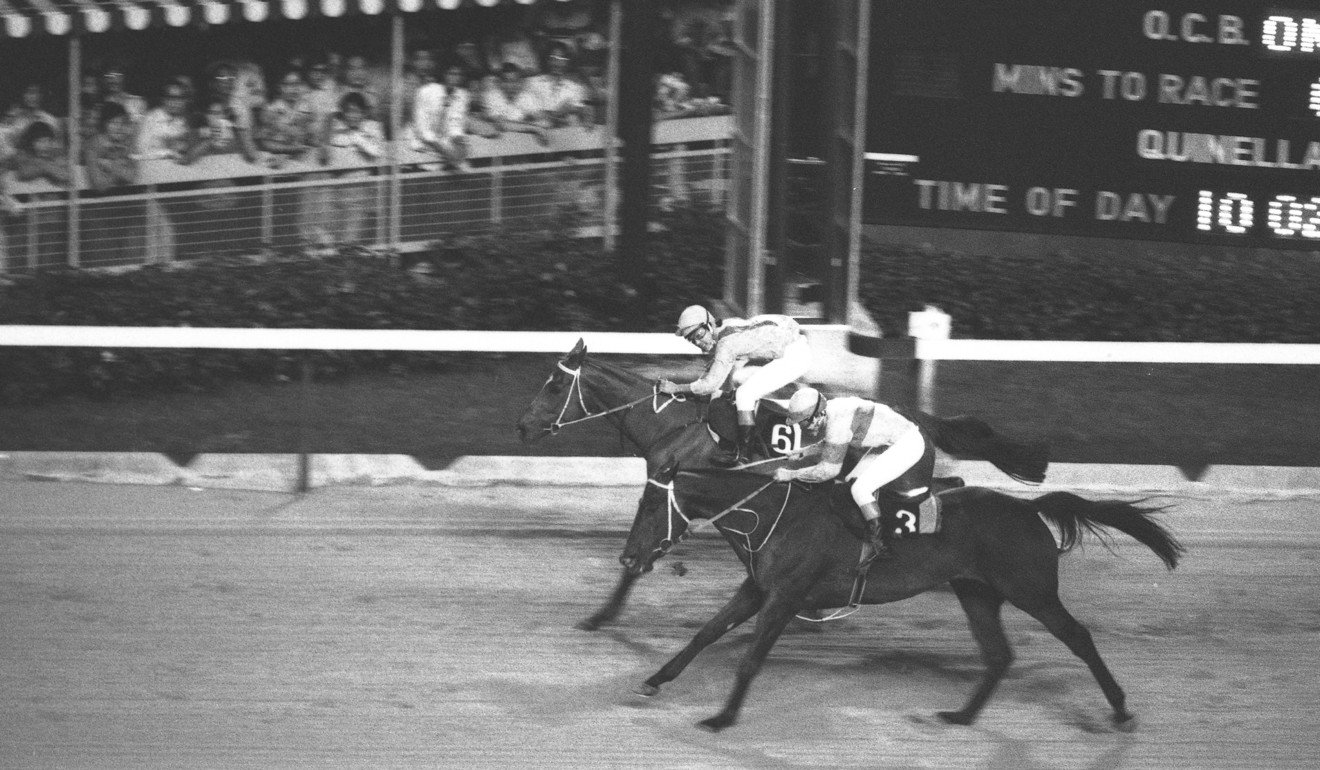 The finish of a horse race – with a packed spectator stand – during a 1970s meeting held by the Royal Hong Kong Jockey Club at Happy Valley Racecourse