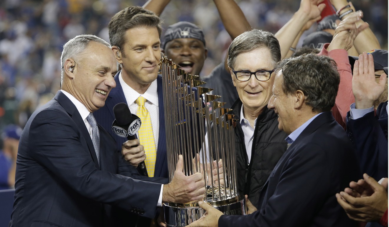 Boston Red Sox owner John Henry (second right) and chairman Tom Werner are handed the World Series trophy. Photo: EPA