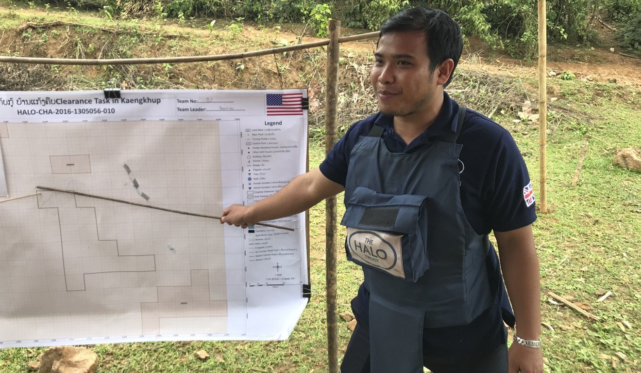 Gah, a local member of the Halo Trust team, refers to an unexploded ordnance survey map in Xépôn. Picture: Padraic Convery