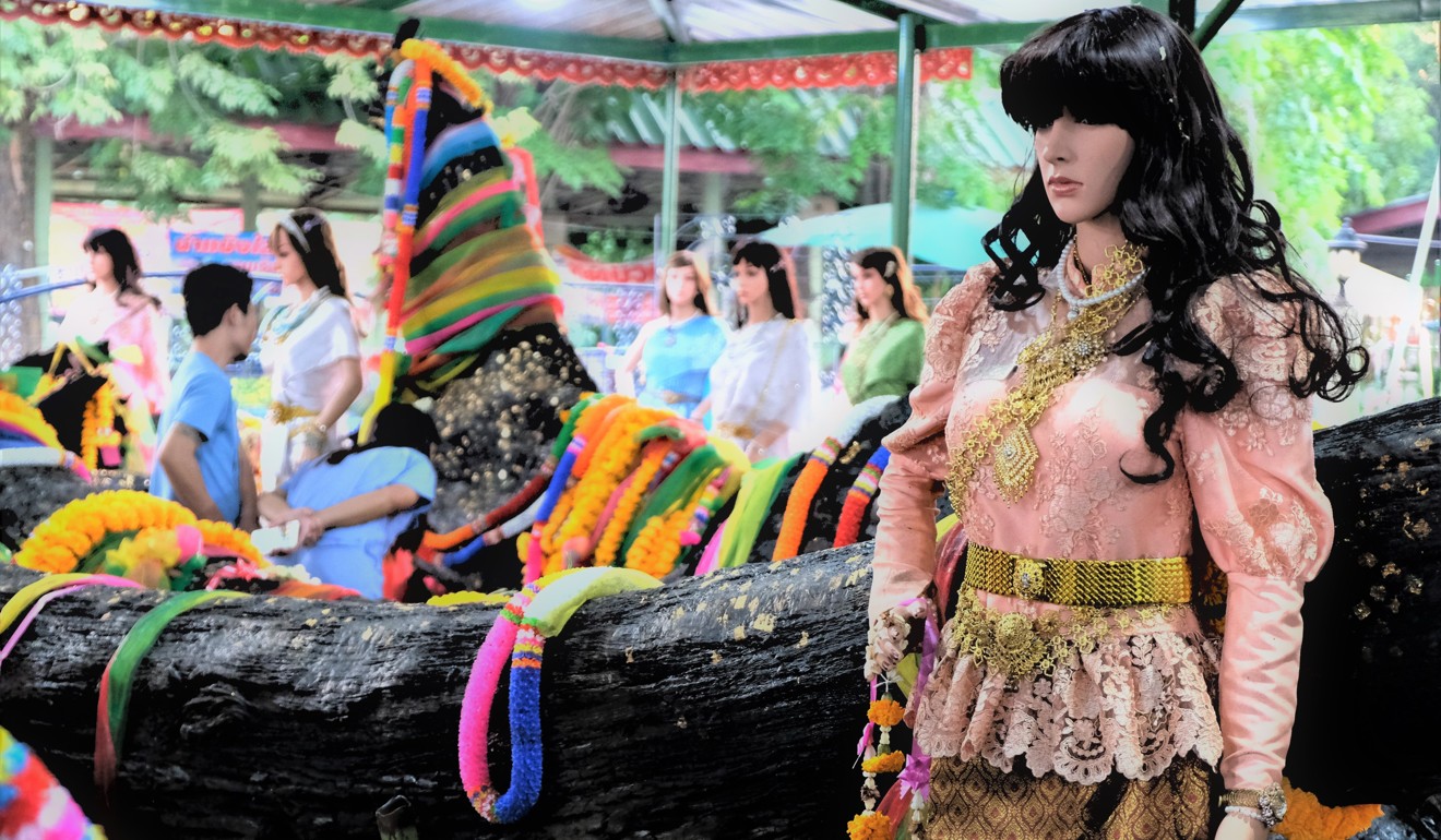 A mannequin, symbolising Nong Ta-khian (Lady of the Ta-khian Tree), stands by a sacred trunk at a Buddhist temple in rural Pathum Thani province, Thailand. Photo: Tibor Krausz