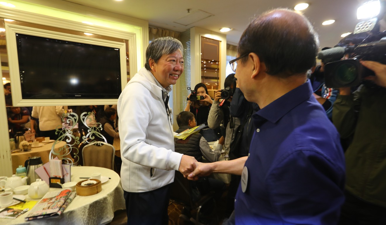 Labour Party candidate Lee Cheuk-yan (left) shakes hands with independent candidate Frederick Fung Kin-kee (right) in a Chinese restaurant in Shek Kip Mei on Sunday morning. Photo: Edmond So