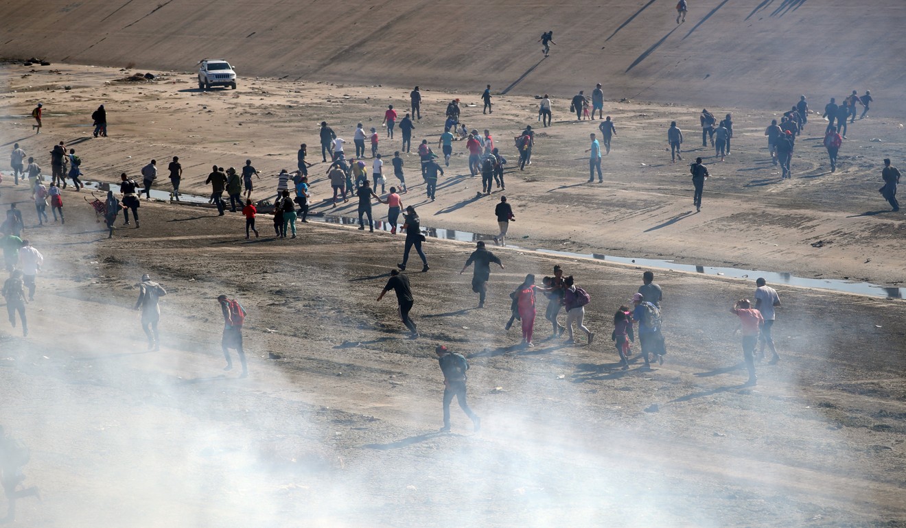 Migrants from Central America trying to reach the US run from tear gas on November 25, 2018. Photo: Reuters